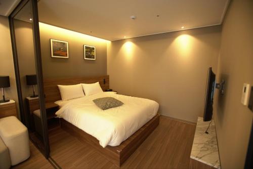 a small bedroom with a bed and a mirror at Haeundae La Mer in Busan