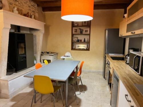 une cuisine avec une table et des chaises jaunes dans l'établissement Gîte authentique avec cheminée, terrasse et WiFi en Charente - FR-1-653-119, à RiviÃ¨res