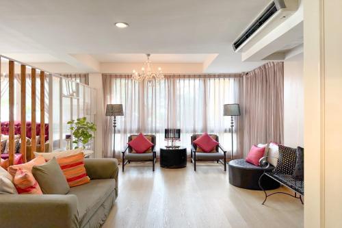a living room with a couch and chairs and a chandelier at Rasa Boutique Hotel Chiang Rai in Chiang Rai