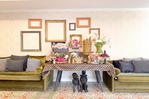 a living room with a table and two couches at Rasa Boutique Hotel Chiang Rai in Chiang Rai