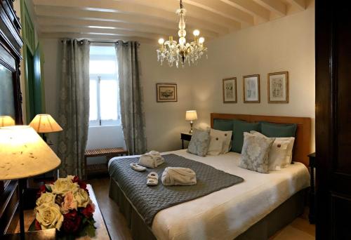 una camera da letto con un letto grande con un lampadario di Casa Do Tanque a Nordestinho