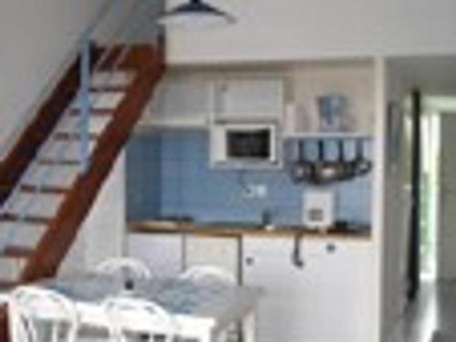 une cuisine avec un escalier, une table et des chaises dans l'établissement Appartement 2 pièces 6 couchages avec parking, vue mer - FR-1-825-3, à La Rochelle