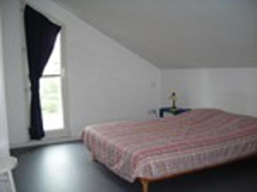 un lit dans une chambre blanche avec une fenêtre dans l'établissement Appartement 2 pièces 6 couchages avec parking, vue mer - FR-1-825-3, à La Rochelle