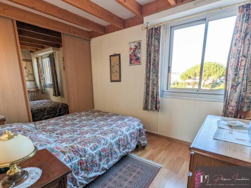 une chambre avec un lit et une fenêtre dans l'établissement Duplex avec piscine et vue sur l'océan à La Rochelle - FR-1-825-14, à La Rochelle