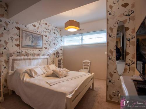 - une chambre avec un lit et un mur orné de fleurs dans l'établissement Agréable T3 avec terrasse et parking à La Rochelle - FR-1-825-12, à La Rochelle