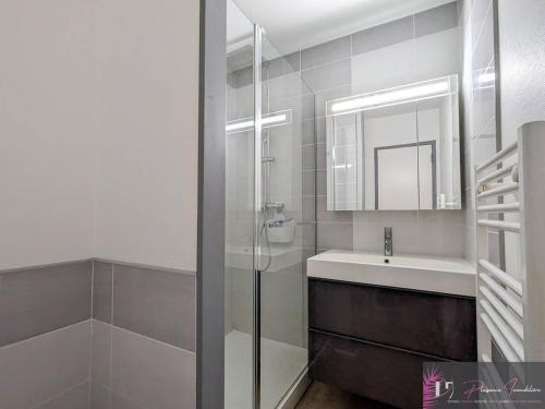 une salle de bain avec une douche, un lavabo et un miroir dans l'établissement Appartement rénové au pied de la plage avec balcon et parking - FR-1-825-46, à La Rochelle