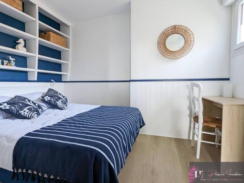 une chambre avec un lit et un miroir au mur dans l'établissement Appartement rénové au pied de la plage avec balcon et parking - FR-1-825-46, à La Rochelle