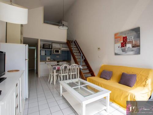 un salon avec un canapé jaune et une cuisine dans l'établissement 2 pièces - 6 couchages, vue mer, parking privé - FR-1-825-13, à La Rochelle