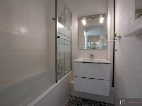 une salle de bain blanche avec un lavabo et une douche dans l'établissement Studio bis avec balcon à La Rochelle, parking inclus - FR-1-825-16, à La Rochelle
