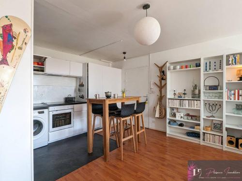 une cuisine avec une table et des chaises dans une pièce dans l'établissement Agréable T2 lumineux au pied de la plage avec WIFI - FR-1-825-52, à La Rochelle