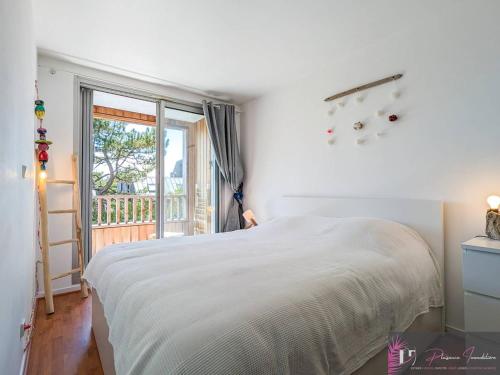 une chambre blanche avec un lit et un balcon dans l'établissement Agréable T2 lumineux au pied de la plage avec WIFI - FR-1-825-52, à La Rochelle