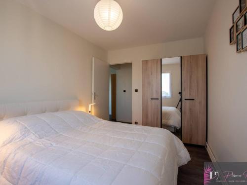 - une chambre avec un grand lit blanc et une lumière dans l'établissement Charmant appartement 2 pièces près de la plage à La Rochelle - FR-1-825-17, à La Rochelle