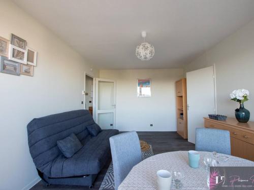 un salon avec un canapé bleu et une table dans l'établissement Charmant appartement 2 pièces près de la plage à La Rochelle - FR-1-825-17, à La Rochelle