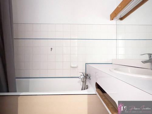 une salle de bain avec une baignoire et un lavabo dans l'établissement Appartement T2 meublé avec parking à 200m de la plage - FR-1-825-18, à La Rochelle