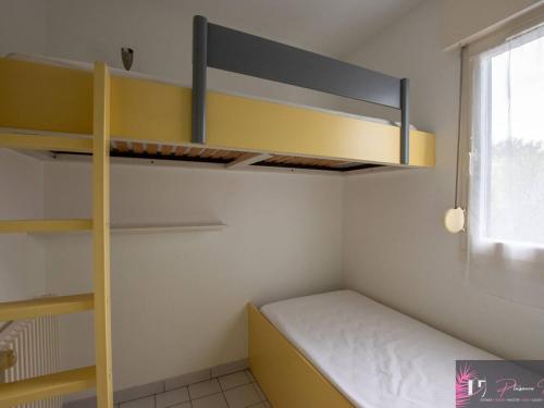 Cette petite chambre comprend des lits superposés et une fenêtre. dans l'établissement Studio meublé 4 pers, terrasse et parking proche mer - FR-1-825-23, à La Rochelle