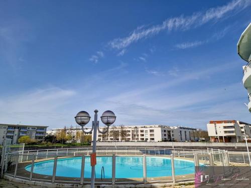 - une piscine avec deux lumières à côté d'un bâtiment dans l'établissement Grand duplex avec terrasse et piscine - FR-1-825-62, à La Rochelle