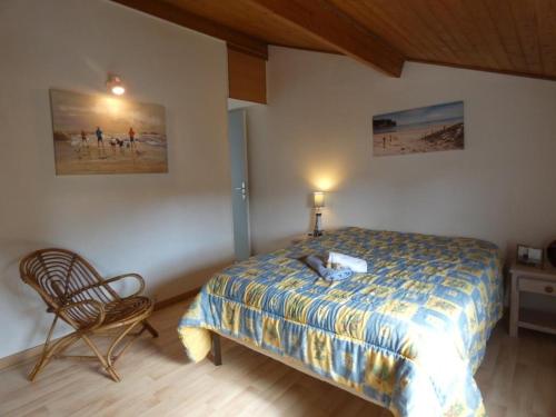 une chambre avec un lit et une chaise dedans dans l'établissement Maison de vacances à Fromentine proche plage, quartier prisé, terrasse, parking - FR-1-540-319, à La Barre-de-Monts