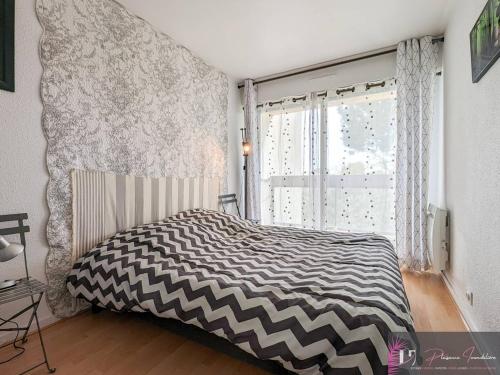 une chambre avec un lit noir et blanc et une fenêtre dans l'établissement Appartement T2 meublé, 4 couchages proche port - FR-1-825-49, à La Rochelle