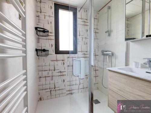 une salle de bain blanche avec une douche et un lavabo dans l'établissement Appartement T2 meublé, 4 couchages proche port - FR-1-825-49, à La Rochelle