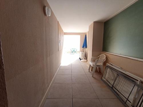 un couloir avec une chambre dotée d'une table et d'une chaise dans l'établissement Studio rénové front de mer avec climatisation et animaux admis, idéal pour 2 personnes à Sète - FR-1-338-606, à Sète