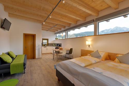 a bedroom with a large bed and a kitchen at Appartement Albert und Helene Koller in Söll