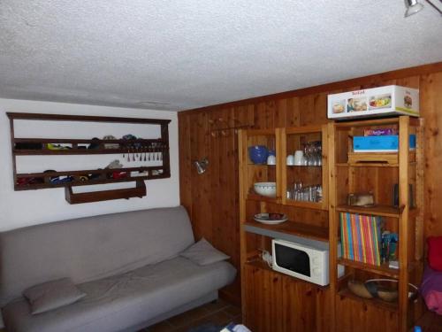 - un petit salon avec un canapé et une étagère dans l'établissement Studio confortable au Sauze, proche pistes, 4 couchages - FR-1-804-53, à Enchastrayes