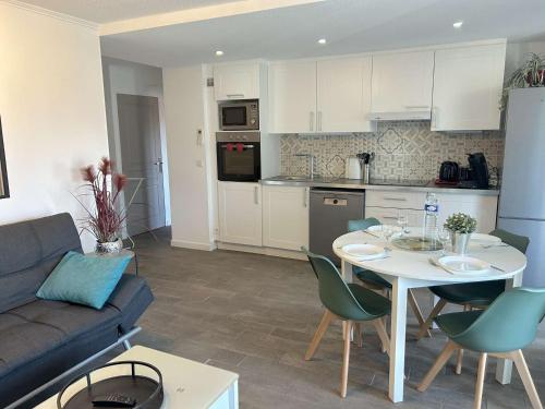 Il dispose d'une cuisine et d'un salon avec une table et un canapé. dans l'établissement Appartement spacieux 3 pièces, climatisé avec parking à Saint-Raphaël - FR-1-226A-202, à Saint-Raphaël