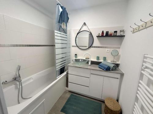 une salle de bain avec une baignoire, un lavabo et un miroir dans l'établissement Appartement spacieux 3 pièces, climatisé avec parking à Saint-Raphaël - FR-1-226A-202, à Saint-Raphaël
