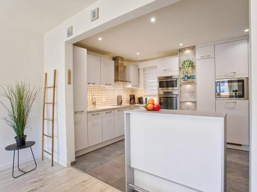 une cuisine avec des armoires blanches et un comptoir dans l'établissement Appartement à Cabourg avec Balcon et Cuisine Équipée - FR-1-788-57, à Cabourg