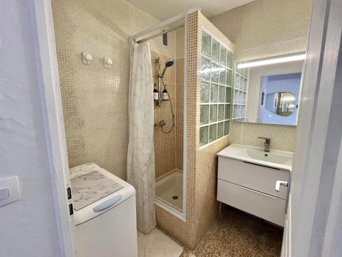 une salle de bain blanche avec une douche et un lavabo dans l'établissement Appartement lumineux sur plage avec piscine et parking - FR-1-716-81, au Grau-du-Roi