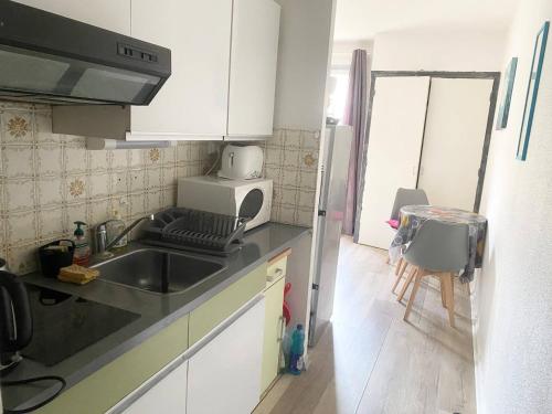une petite cuisine avec un évier et un réfrigérateur dans l'établissement Studio ensoleillé en centre-ville, animaux admis - FR-1-703-206, à Amélie-les-Bains-Palalda