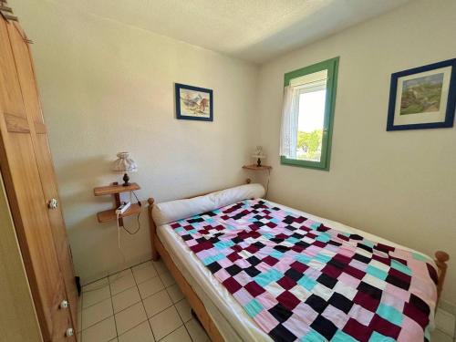 une chambre avec un lit avec une couette colorée dans l'établissement T2 Cabine Climatisé avec Parking à Argelès-sur-Mer - FR-1-388-231, à Argelès-sur-Mer