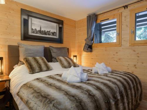 a large bed in a room with wooden walls at Courchevel 1850: Duplex charmant 6 pers près centre, parking, wifi - FR-1-631-228 in Courchevel