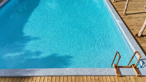 an overhead view of a swimming pool with two chairs at Tropical Magnolia in Hellgate