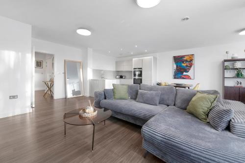 a living room with a couch and a table at Heart Of Stratford Olympic Park 3 Bedroom in London