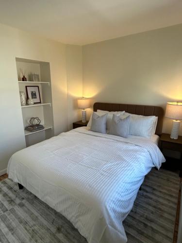 a bedroom with a large white bed with two lamps at NEW! Historic Townhouse-14 min to WTC in Jersey City