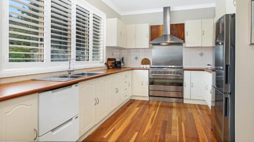 a kitchen with white cabinets and a stainless steel refrigerator at Somerset in Robertson