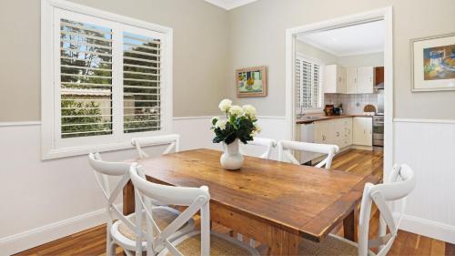 a dining room with a wooden table and white chairs at Somerset in Robertson