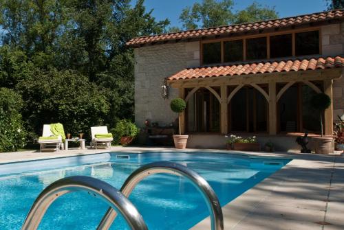 a swimming pool in front of a house at Moulin De Larcy in Ribérac