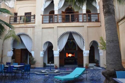 a courtyard with chairs and a fire in a building at Riad Lotus Bleu in Fès