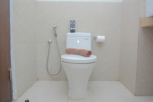 a bathroom with a toilet with a roll of toilet paper at Cozy and Best Choice Studio at Bogor Icon Apartment By Travelio in Bogor