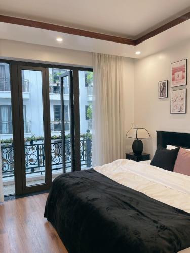 a bedroom with a large bed and a balcony at C&K Premier Apartment Hai Phong in Hai Phong