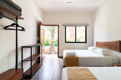 a bedroom with two beds and a window at Casa Ámbar, tu casa en Mérida in Mérida