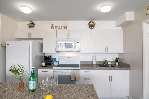 a kitchen with white cabinets and a counter with wine glasses at 18Fl Ocean Views, AC, Parking, Near Waikiki Beach in Honolulu