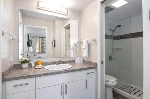 a white bathroom with a sink and a shower at 18Fl Ocean Views, AC, Parking, Near Waikiki Beach in Honolulu