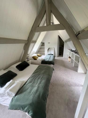 une chambre avec un grand lit dans un grenier dans l'établissement Charmante chaumière, à Fierville-les-Parcs