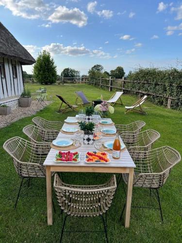 une table avec des plaques de nourriture dans une cour dans l'établissement Charmante chaumière, à Fierville-les-Parcs
