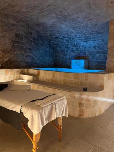 a bed in a room with a stone wall at Un giorno bellissimo suite & spa in Martina Franca