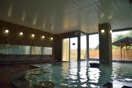 a large swimming pool with a clock in a building at ホテル作州武蔵 in Mimasaka