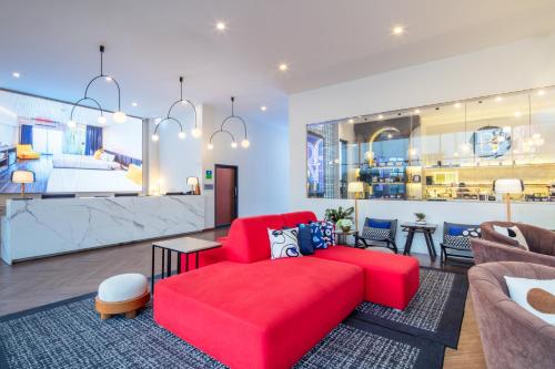 a living room with a red couch and a table at SureStay by Best Western Iconic Ari-Jatujak in Bangkok